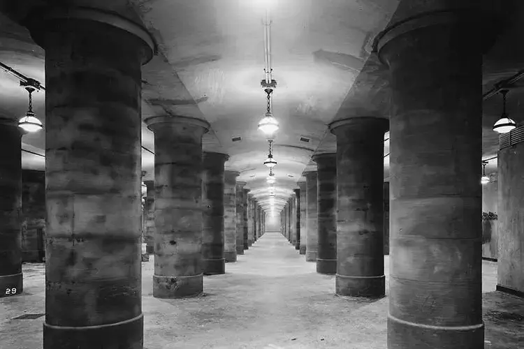 Photo de la souterraine, la réserve d'or de la France. On peut y apercevoir les impressionnants piliers de la salle ainsi que la longueur interminable du couloir. Plusieurs lustres sont suspendus au plafond.